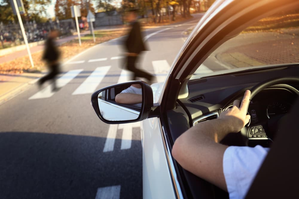 Driver yielding to pedestrians on the crosswalk.